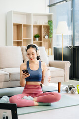 A young woman practices yoga and stretching with a mat and gym props, showcasing wellness,...