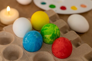 Decorating colorful Easter eggs with a palette and candles during spring festivities
