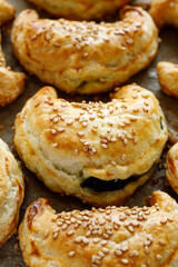 Close-up view of sesame-sprinkled croissants,  crescents with vegetarian spinach-cheese filling