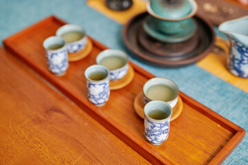 Blue patterned teacups neatly arranged on wooden tray during Chinese tea ritual, showcasing aesthetic presentation and cultural refinement