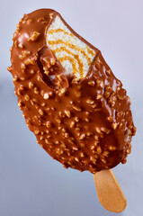  Schokoladeneis am Stiel mit Haselnuss und Caramelstreifen im Vanilleeis, Eiscreme, isoliert, Eis am Stiel,
