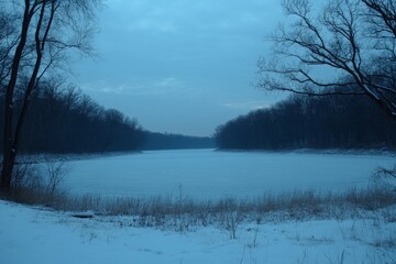 Frozen river landscape at dusk with bare trees and snow-covered banks in a serene winter setting