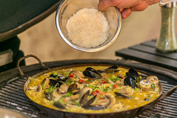 The chef prepares a traditional seafood paella on the grill.Traditional spanish dish. Fresh and Colorful Spanish Seafood Paella. Mediterranean cuisine and seafood dishes.