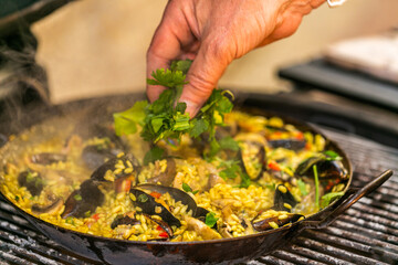 The chef prepares a traditional seafood paella on the grill.Traditional spanish dish. Fresh and Colorful Spanish Seafood Paella. Mediterranean cuisine and seafood dishes.