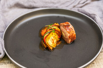 Chef preparing traditional Provençal vegetable dish Ratatouille with stuffed rolled meat on the grill. French food. Healthy eating. Delicious vegetable
