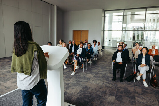 Female business leader speaking at a conference with an engaged audience
