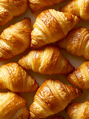 Golden brown croissants close-up, flaky pastry, buttery texture, French breakfast, bakery goods, food photography, gourmet pastries, delicious treats, warm tones, appetizing display