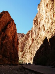 Scenic mountain gorge with steep rocky cliffs under a clear blue sky in Todra Gorge, Morocco