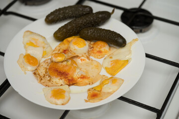 pickled cucumbers and  chicken egg with 9 quail eggs. Home cooking. Fried quail eggs in frying pan.