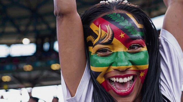 Smiling Vanuatuan sports fan with vibrant flag face paint cheering at a stadium  
