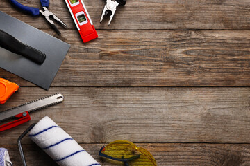 Different construction materials and tools on wooden table, flat lay. Space for text