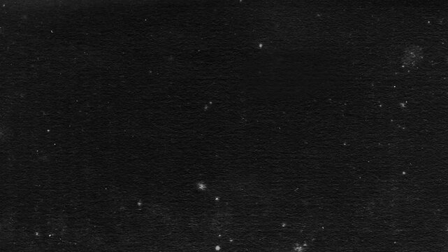 Abstract black background animation of a grunge textured old paper. 4K Seamless loop. Slideshow. Low frame rate effect.