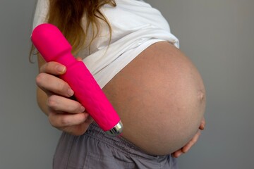 pregnant woman holding pink vibrator