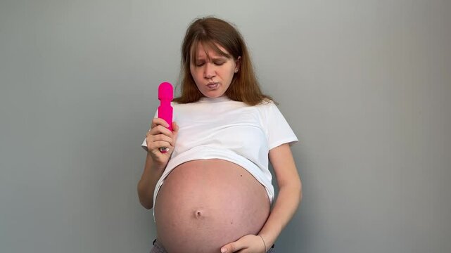 pregnant woman holding pink vibrator
