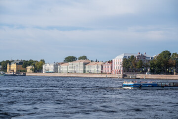 Obraz premium Beautiful waterfront view of historical buildings along the river in Saint Petersburg showcasing the vibrant architecture and serene atmosphere