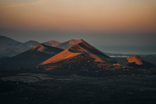 Aerial view of a dramatic volcanic landscape at sunset with rugged mountains and barren terrain, Fuente de Montana Negra, Lanzarote, Canary Islands.