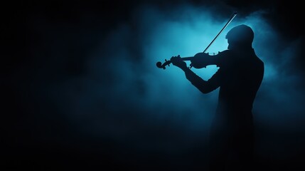Silhouette of violinist playing against moody blue foggy background. Music and performance concept