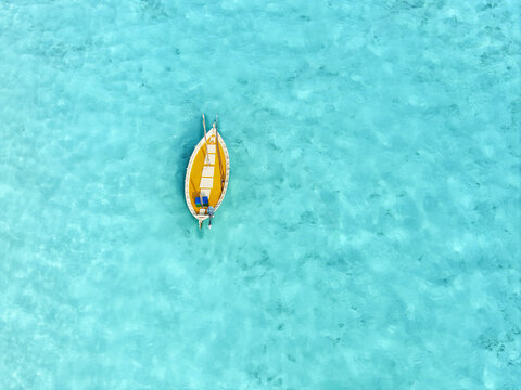 Aerial view of a traditional dhoni sailing through tranquil turquoise waters of the ocean, Bileyfahi, Shaviyani Atoll, Maldives.