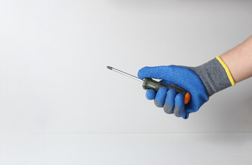 screwdriver in hand in blue glove