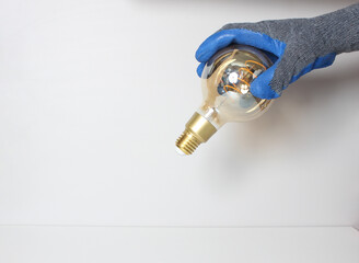 light bulb in hand in blue glove