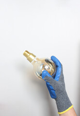 light bulb in hand in blue glove