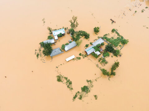 Aerial view of flooded village with submerged houses and roads amidst trees, Jhenaigati, Sherpur, Bangladesh.