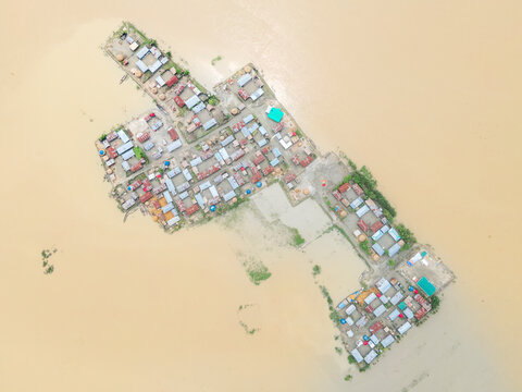 Aerial view of a devastated and submerged village with floating homes and flooded streets, Kurigram, Kurigram, Bangladesh.