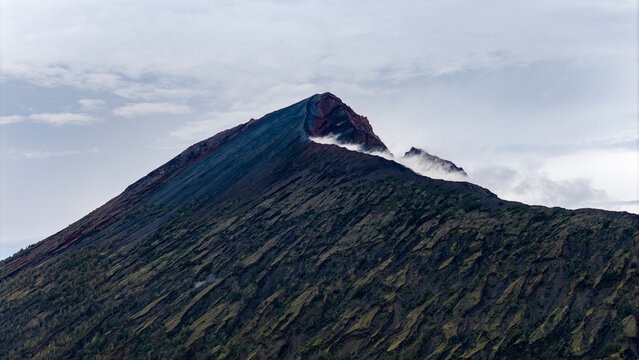 Aerial drone view of the top of active Rinjani volcano above the clouds, island of Lombok, Indonesia