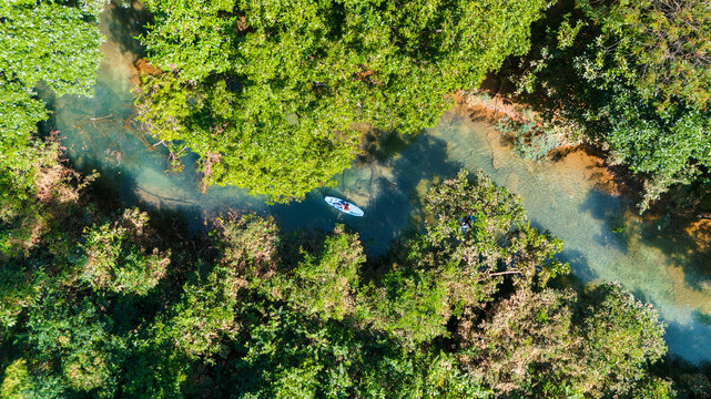 Aerial drone view of kayak in transparant water near Kong Lor cave, Laos, Southeast Asia