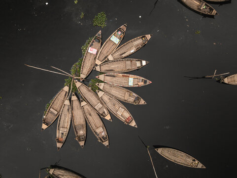 Aerial view of traditional wooden boats docked along the clear Buriganga river, Lalbagh Thana, Dhaka, Bangladesh.