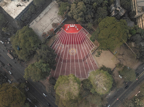 Aerial view of central shaheed minar surrounded by greenery and urban landscape, Shahbag, Dhaka, Bangladesh.