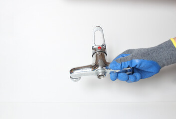 water tap in a hand in a blue glove