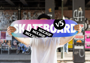 Mockup of a Skater holding a Skateboard Deck