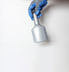 car bottle in the hand in a blue glove