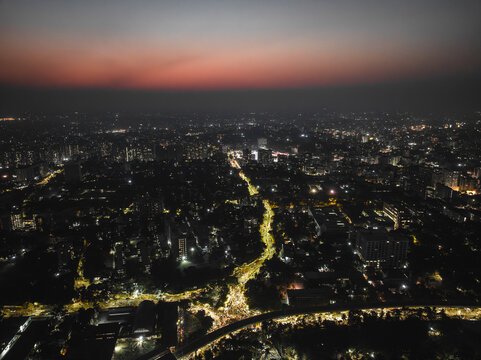 Aerial view of a vibrant cityscape with illuminated skyline and bustling streets at night, Shahbag, Dhaka, Bangladesh.