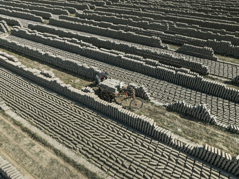 Aerial view of brick fields and factory with people engaged in manual labor, Suti Para Union, Dhamrai, Dhaka, Bangladesh.