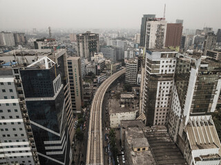 Aerial view of bustling cityscape with modern skyscrapers and railway in a vibrant urban environment, Paltan Thana, Dhaka, Bangladesh.