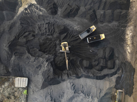 Aerial view of a coal factory with cranes and excavators in a bustling industrial area, Amin Bazar, Savar, Dhaka, Bangladesh.