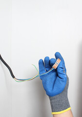 Wires for wires in a hand in a blue glove