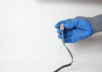 Wires for wires in a hand in a blue glove