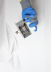 Spare parts of the microwave in the hand in a blue glove