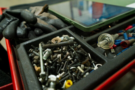 Screws tools equipment of mechanic in workshop. Modern digital tools of modern mechanic, digital tablet computer in the background