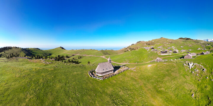 Aerial view of tranquil alpine pasture with rustic chalets and serene meadows, Velika Planina, Kamnik, Slovenia.