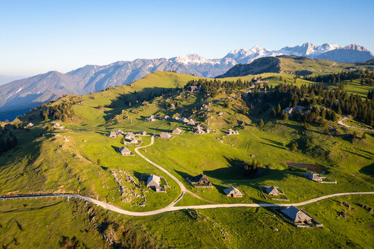Aerial view of picturesque alpine pasture with traditional chalets and cabins in a serene mountain landscape, Velika Planina, Kamnik, Slovenia.