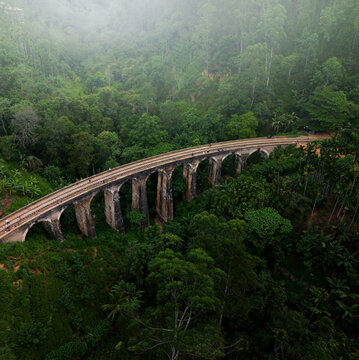 Aerial view of the historic 9 Arches Bridge surrounded by lush green forest and natural landscape, Gotuwela, Badulla District, Sri Lanka.