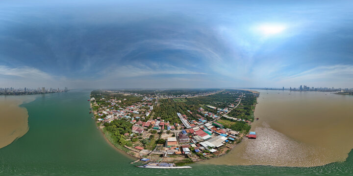 Aerial view of the tranquil Mekong and Tonle Sap rivers with scenic rooftops and greenery in Lvea Aem District, Kandal, Cambodia.