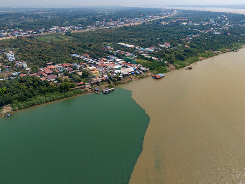 Aerial view of the serene Mekong and Tonle Sap rivers surrounded by lush greenery and urban buildings, Akreiy Ksatr, Lvea Aem District, Kandal, Cambodia.