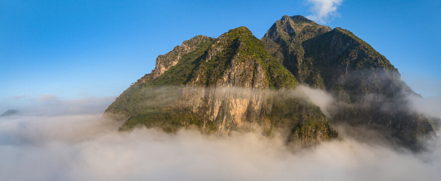 Aerial view of Nong Khiaw above the fog with majestic mountains and serene sky, Ngoy District, Luang Prabang, Laos.