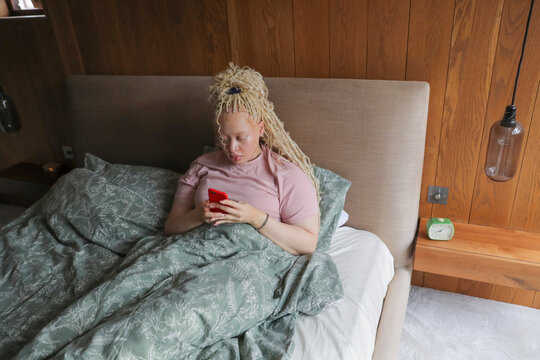 Woman with smart phone in bed