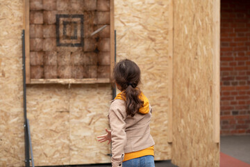 Cute little girl is ready for throwing knife to the target
